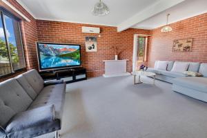 una sala de estar con una pared de ladrillo en Harmony, en Lakes Entrance