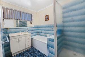 baño azul y blanco con bañera y lavamanos en Harmony, en Lakes Entrance 10 fotos más