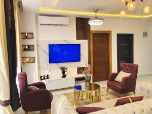 アクラにあるMankatiwa Court Apartmentsのソファとテレビのあるリビングルーム