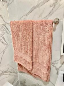 アクラにあるMankatiwa Court Apartmentsのバスルームのタオル掛けに掛けられたピンクのタオル +26枚の写真