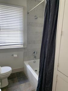 a bathroom with a tub and a toilet and a sink at Cute & Quiet Garage Apt Home in Houston