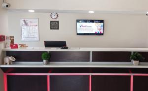 a reception desk with a laptop on the wall at Red Roof Inn Moss Point in Moss Point
