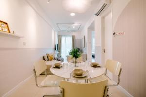 a white dining room with a table and chairs at Nordic Design 2BR Premium Suite, near Desa ParkCity, KL in Kuala Lumpur