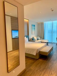 a bedroom with a large bed and a mirror at Panoramic sea homestay in Ha Long