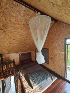 1 dormitorio con 1 cama con mosquitera en hueankwankao เฮือนขวัญข้าว, 