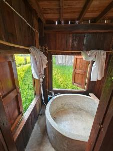 bañera antigua en una habitación con ventana en hueankwankao เฮือนขวัญข้าว, 