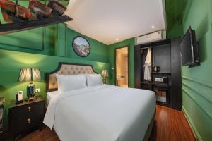 1 dormitorio con cama blanca y paredes verdes en Madelise Adora Hotel & Travel en Hanói