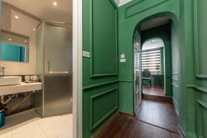 ein grünes Bad mit einem Waschbecken und einer Dusche in der Unterkunft Madelise Adora Hotel & Travel in Hanoi