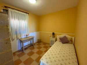 a small bedroom with a bed and a table at Casas ALBERTO TELEWORKING in San Miguel de Abona