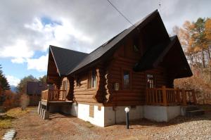 une cabane en rondins avec un toit noir dans l'établissement Shakunagedaira Rental Cottage - Vacation STAY 18468v, à Numajiri