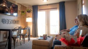 zwei Frauen sitzen in einem Wohnzimmer mit Blick aus dem Fenster in der Unterkunft Mountain View Lodge in Chelan