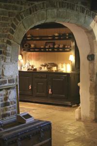 a kitchen with black cabinets and a stone wall at Gastenlogies Blauwe Schaap in Ranst