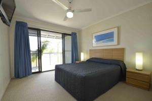a bedroom with a bed and a large window at Ivory Palms Resort Noosa in Noosaville