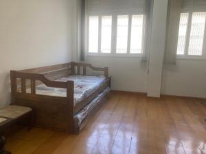 a bedroom with two beds in a room with wooden floors at Apartamento no Hotel Quitandinha 40 in Petrópolis