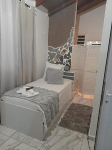 a small bedroom with a bed and a mirror at Lodge Ti-Kaco Vanille in Trois-Rivières