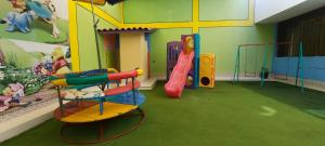 uma sala de jogos para crianças com escorrega e equipamento de brincar em CASA TESORITOS em Urbanizacion Buenos Aires