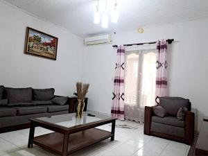 ein Wohnzimmer mit einem Sofa und einem Couchtisch in der Unterkunft Chez Nofy Toamasina in Toamasina