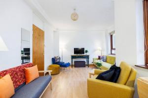 een woonkamer met banken en stoelen en een televisie bij Kings Cross Suite in Londen