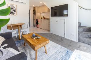 een woonkamer met een bank en een tafel bij Modern, Convenient, Central: 1 bedroom loft in Christchurch