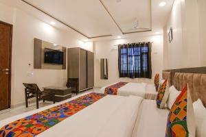 a hotel room with two beds and a television at FabHotel Aryan Grand in Amritsar