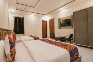 a hotel room with two beds and a tv at FabHotel Aryan Grand in Amritsar