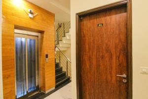 a hallway with a wooden door and stairs at FabHotel Aryan Grand in Amritsar
