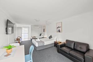 a living room with a bed and a couch at Pottsville Beach Motel in Pottsville