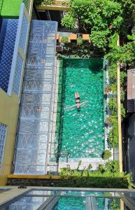 an aerial view of a person in a pool of water at Villa De Pi's Hoi An in Hoi An