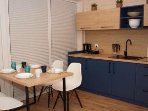 - une cuisine avec une table en bois et des chaises blanches dans l'établissement Air-conditioned holiday homes, 2 bedrooms, à Mielenko 19 autres photos