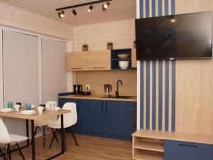a kitchen with blue cabinets and a table and chairs at Comfortable holiday cottages, Mielenko in Mielenko