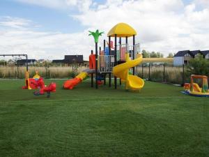 a playground with colorful slides and a play structure at Comfortable holiday cottages, Mielenko in Mielenko