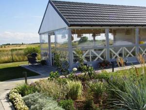 a white pavilion with a bench in a garden at Comfortable holiday home, Mielenko in Mielenko