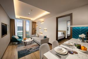 a living room with a couch and a table in a room at Mövenpick Living West Hanoi in Hanoi