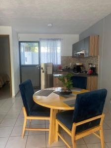 a kitchen with a wooden table and chairs and a kitchen with a refrigerator at Departamento entero Toluquilla HP/VFG/Iteso in Guadalajara