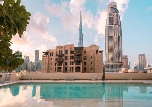 einen Pool mit einer Skyline der Stadt im Hintergrund in der Unterkunft BURJ ROYALE - Luxury 2 bedroom apartment with full burj Khalifa & fountain view- DELUXE in Dubai