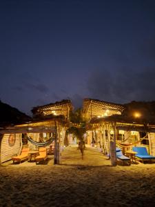 um resort com cadeiras e mesas na praia à noite em Hotel Gabarra Lodge em San Vicente