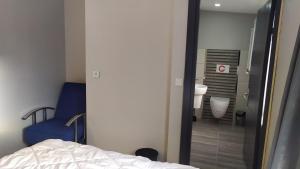 a bedroom with a bed and a blue chair and a bathroom at RAZI TURIZM in Istanbul
