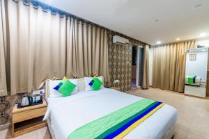 a bedroom with a large white bed and curtains at Treebo Trend Spring Brooks - Koregaon Park in Pune