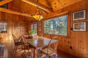 a dining room with a wooden table and chairs at Coziest Cabin in Tahoe w Stone Fireplace Comfy Beds Close to Slopes & Lake in Carnelian Bay