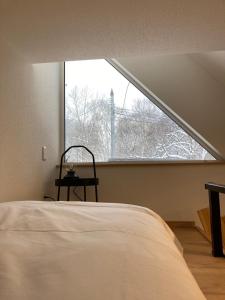 sypialnia z łóżkiem i dużym oknem w obiekcie Niseko STREAM Villas w mieście Rankoshi
