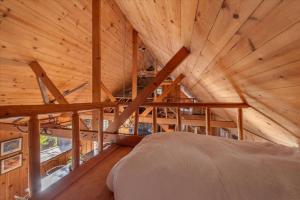 ein Bett in einem Zimmer mit Holzdecke in der Unterkunft Coziest Cabin in Tahoe w Stone Fireplace Comfy Beds Close to Slopes & Lake in Carnelian Bay