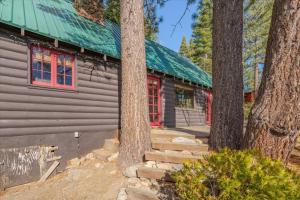 a log cabin with red windows and trees at Coziest Cabin in Tahoe w Stone Fireplace Comfy Beds Close to Slopes & Lake in Carnelian Bay