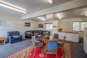 een keuken en woonkamer met een tafel en stoelen bij Lushingtons Bay - Takamatua in Akaroa