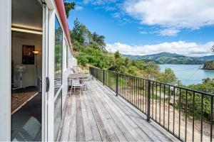 een balkon met uitzicht op het water bij Lushingtons Bay - Takamatua in Akaroa