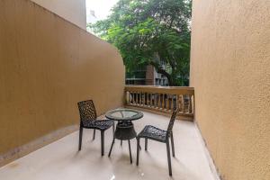 d'une terrasse avec 2 chaises et une table sur un balcon. dans l'établissement Treebo Trend Spring Brooks - Kalyani Nagar, à Pune