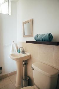 een badkamer met een wastafel, een toilet en een spiegel bij Acogedor departamento con amplia terraza in Lima