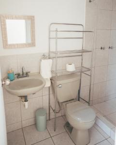 Acogedor departamento con amplia terraza في ليما: حمام مع مرحاض ومغسلة