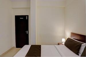 - une chambre avec un lit et une porte noire dans l'établissement OYO Flagship 35467 Shiridi Residency Near Birla Mandir, à Hyderabad