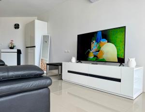 a living room with a television on a white entertainment center at Thawi Studio with Sea View in Chic Condo in Karon Beach +56 photos