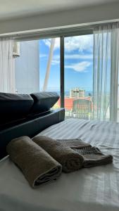 a bedroom with a bed with two towels on it at Thawi Studio with Sea View in Chic Condo in Karon Beach